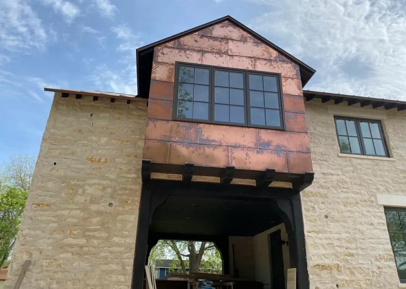 Copper metal panel facade on a stone building for Roof Repair in Poteau